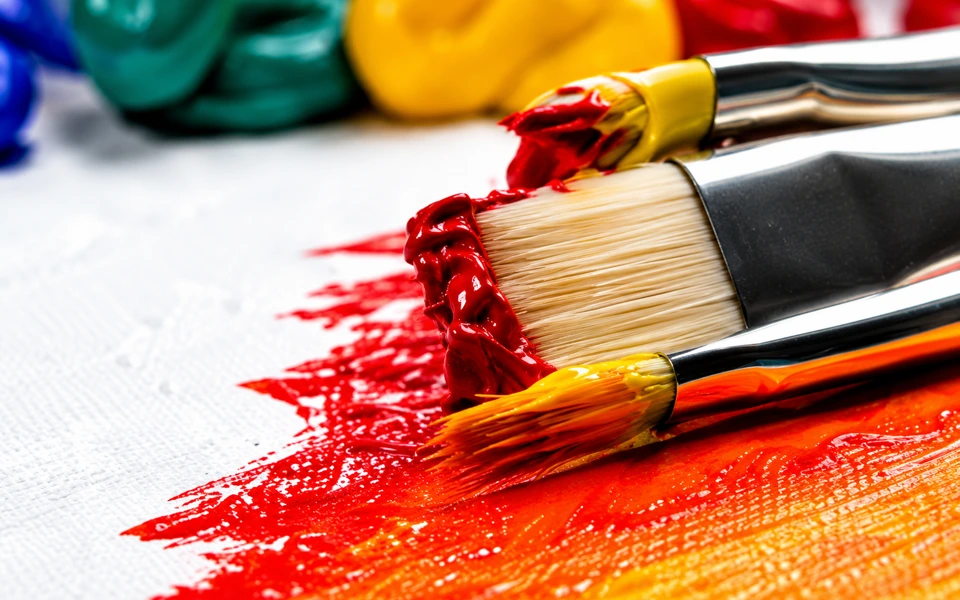 Paintbrushes spreading colorful paint